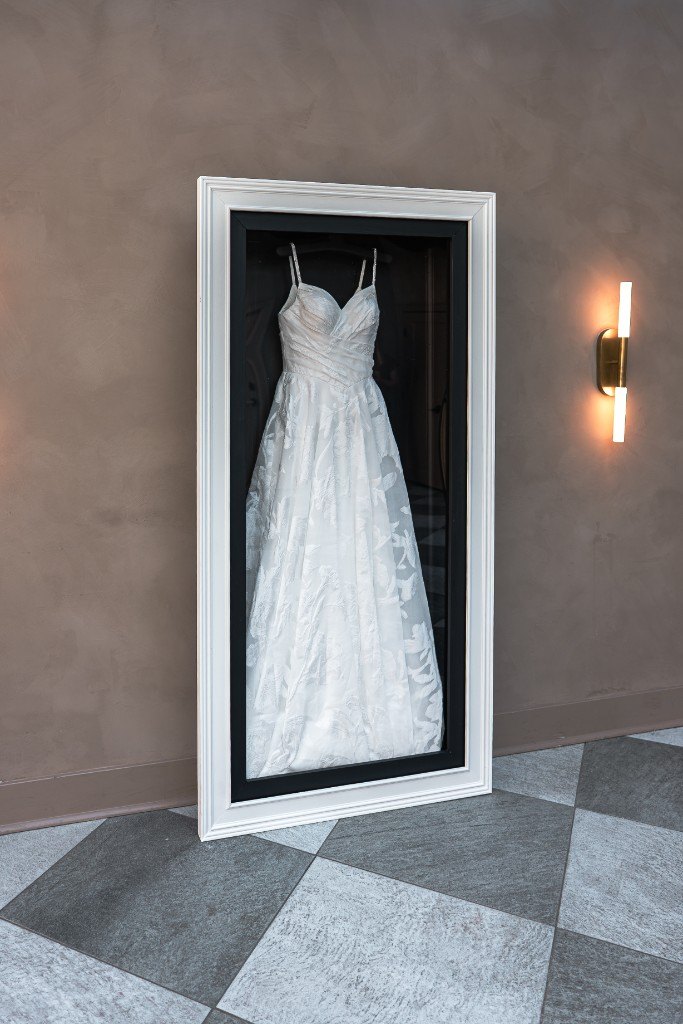 The Mrs. Case Gallery in Black + White, a white frame with a black mat, hanging on a plaster wall